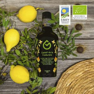 botella de aceite sobre una mesa con 3 limones